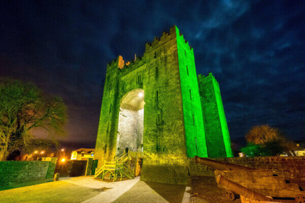 a castle lit up in green transport from Ireland's airports