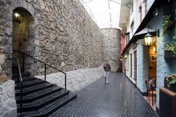 man walking near a tall wall getting around Ireland without a car