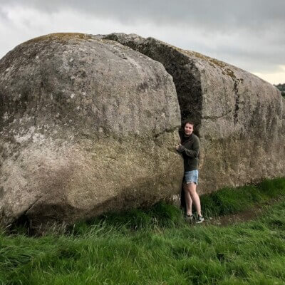 a girl in between an opening in a stone visiting Sligo