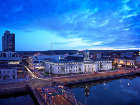 a building by a river at night Cork City