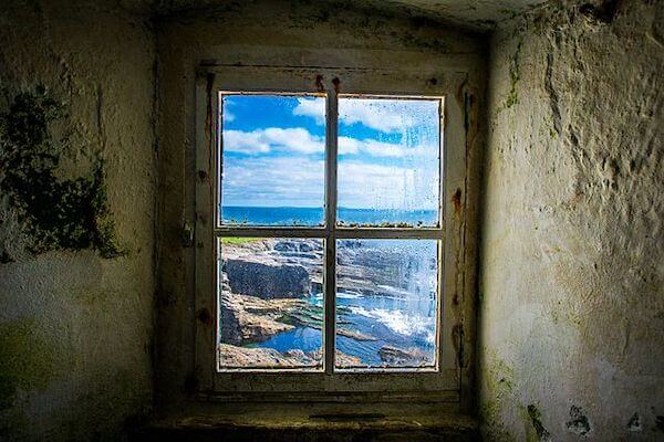 a lighthouse window looking out at ocean Ireland's coolest lighthouses