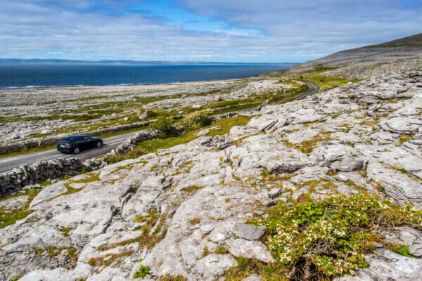 a car on a road in a rocky landscape how to plan a trip along the Wild Atlantic Way