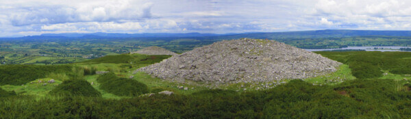a large mound of stones in a field regions of Ireland