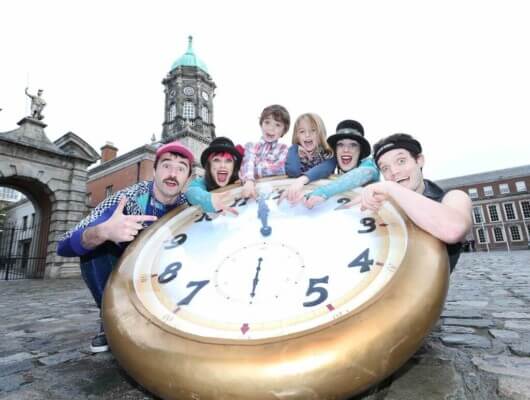 people around a large clock face visiting Dublin for the holidays