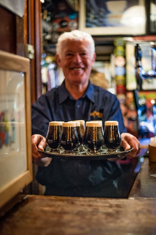 a man holding a tray of drinks the best in Irish food