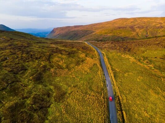 a car on a narrow road how to save money on a trip to Ireland