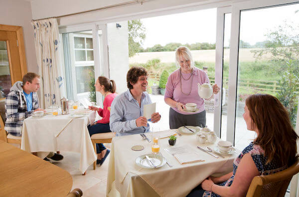 people at a table being served how to save money on a trip to Ireland