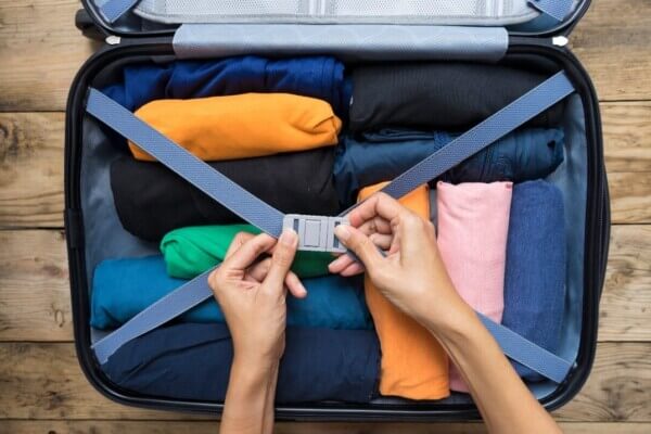 a woman closing a suitcase packing tips for traveling to Ireland