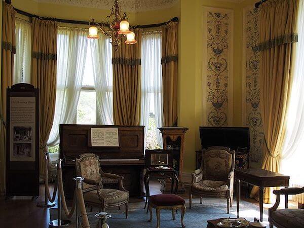a room with a piano and chairs Kylemore Abbey