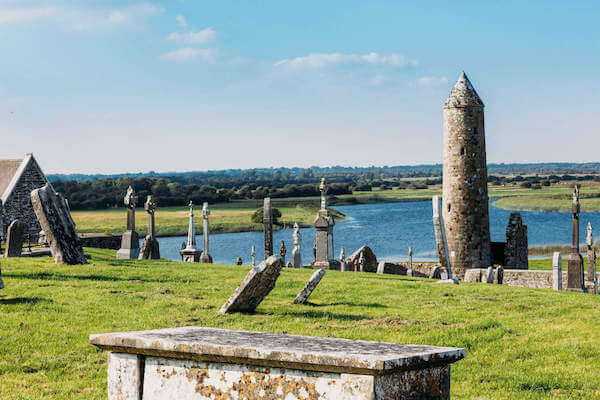 a round tower and grave stones near a river 10 days in Ireland