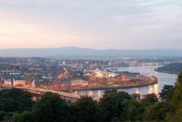 a bridge over a river near a city at night best affordable golf courses in Ireland
