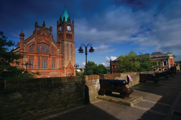 a large building with a clock Bishop's Gate Hotel in Derry