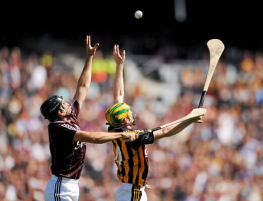 two men reaching for a ball in the air finding the best authentic experiences in Ireland