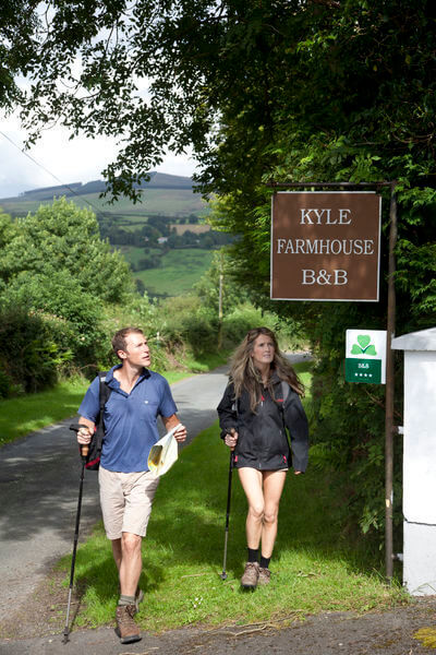 a couple with hiking sticks at a B&B finding the perfect B&B in Ireland
