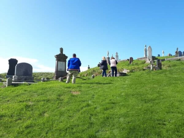 people standing on a hill near headstones Donegal tour guide