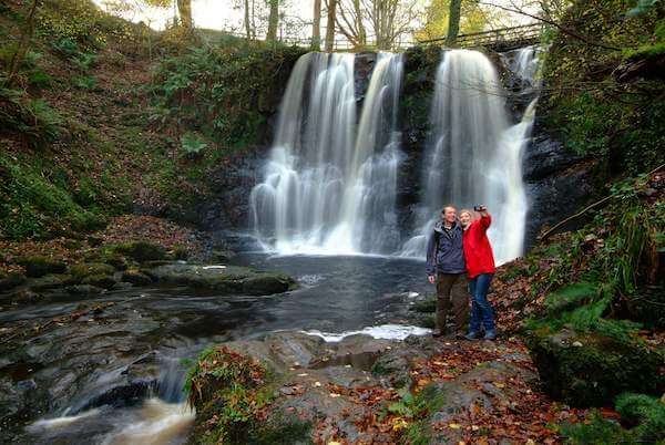 two people standing by a waterfall Ireland in September