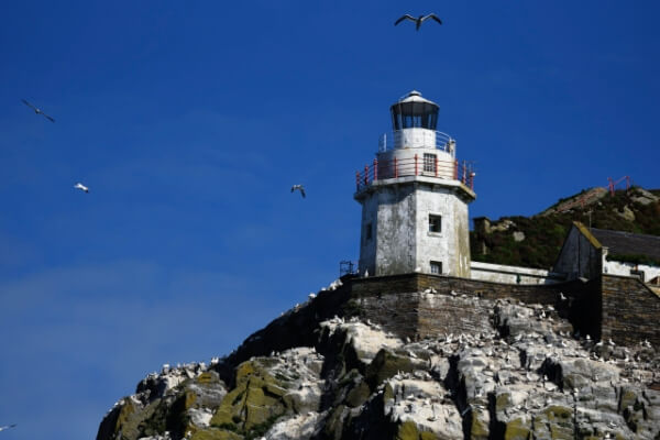 a lighthouse on a cliff 10 gem attractions in Ireland