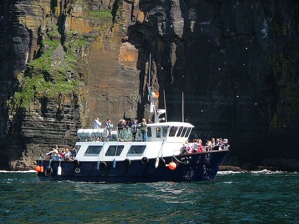 a boat full of people near cliffs how top plan a trip along the Wild Atlantic Way