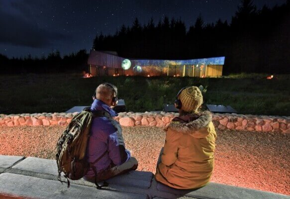 two people sitting on a wall at night Davagh Forest