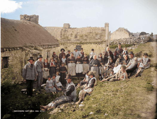 people sitting on grass outside a cottage experience Ireland's past