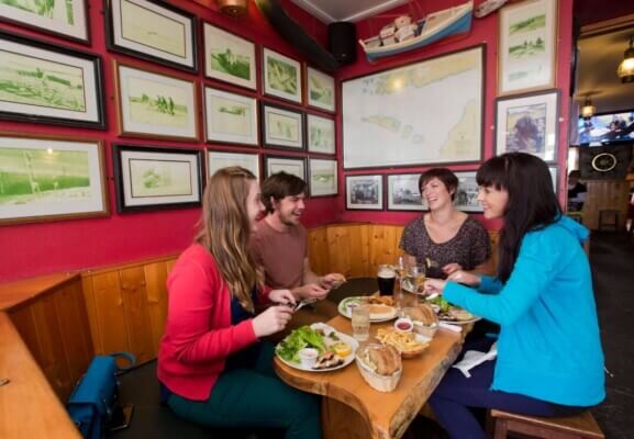people sitting around a table 30 ways to save on your trip to Ireland