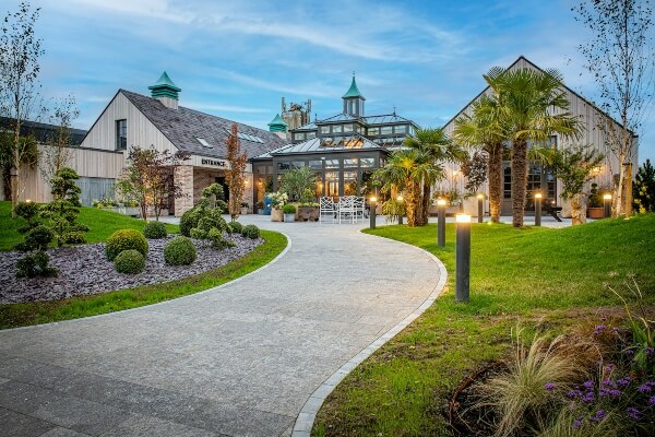 a large building with lights along its entrance path see Ireland's whiskey distilleries