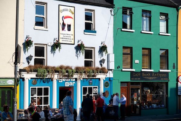people standing in front of a building 14 of Ireland's oldest pubs