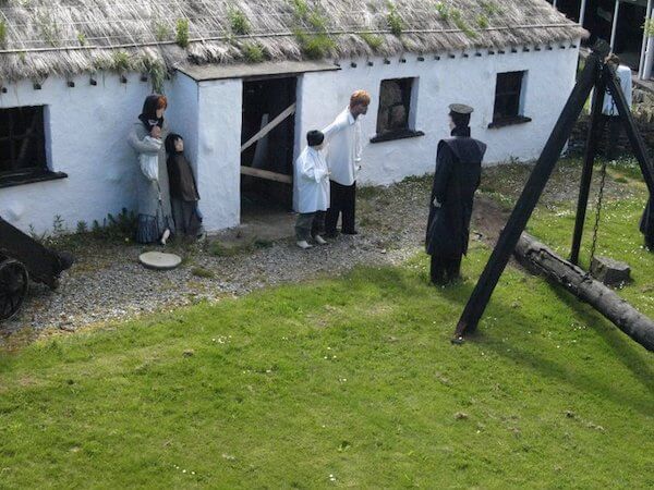 a cottage with people in front of it dark tourism destinations in Ireland