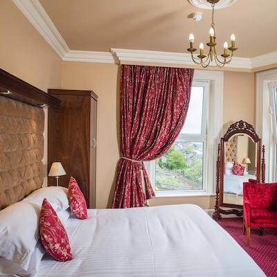 a bedroom with red curtains on window where to stay in Cork City