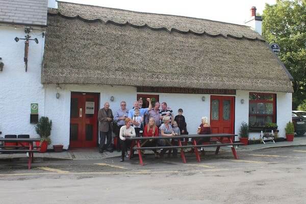 people in front of a thatched roof building Experiencing Ireland Tours