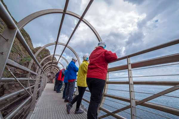 people standing on a tubular bridge The Gobbins new tours