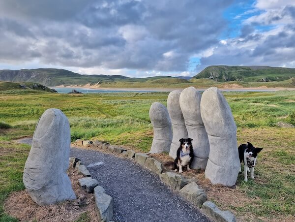 two dogs beside a sculpture donegal travels