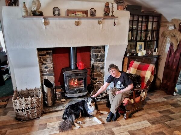 a woman sitting by the fire with a dog donegal travels