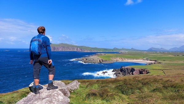 a man standing on a rock overlooking the ocean Hillwalk Tours