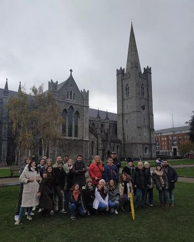 a group of people standing in front of a church 7 ways to save money in Dublin