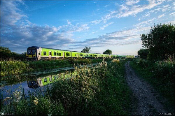 a train near a river using public transportation to see Ireland